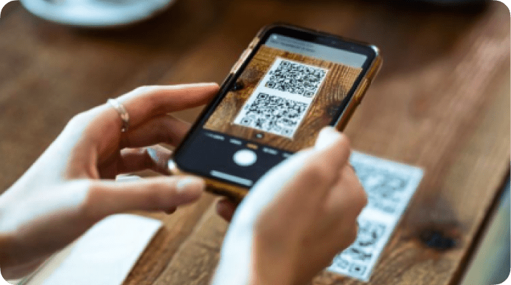 Cliente escaneando código QR del menú en la mesa