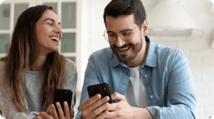 Casal sorrindo, olhando o celular