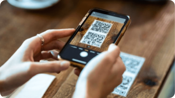 Cliente escaneando um QR code na mesa de um restaurante com o seu celular
